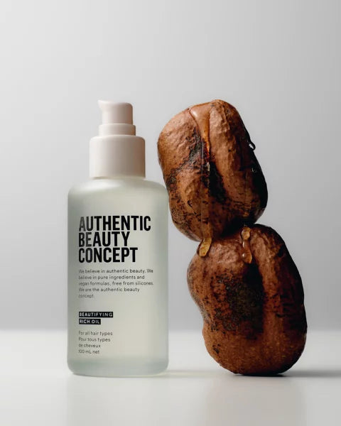Bottle of 'Authentic Beauty Concept' product with two cacao on a light background