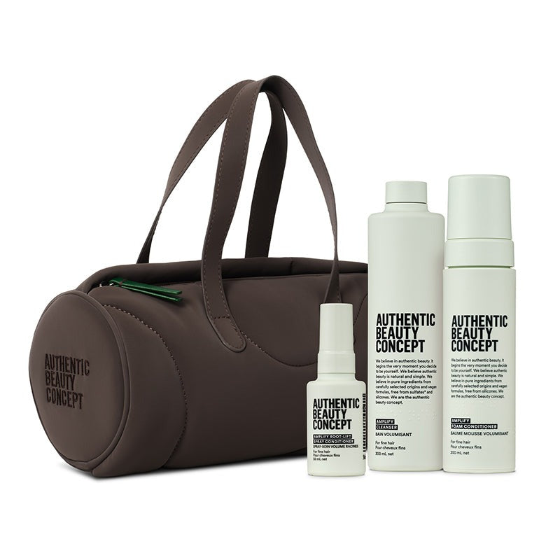 A brown barrel cosmetic bag with dual handles stands next to three amplify products and roof lift spray from Authentic Beauty Concept on a clean white background.