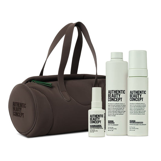 A brown barrel cosmetic bag with dual handles stands next to three amplify products and roof lift spray from Authentic Beauty Concept on a clean white background.