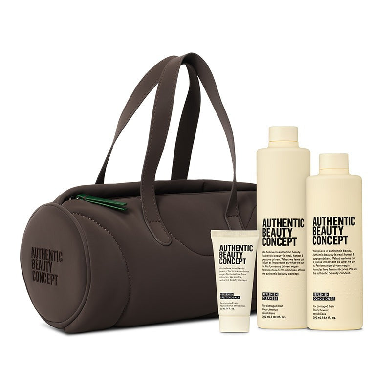 A dark brown barrel bag with two handles, shown alongside three cream-colored Authentic Beauty Concept bottles and a tube on a plain white background.
